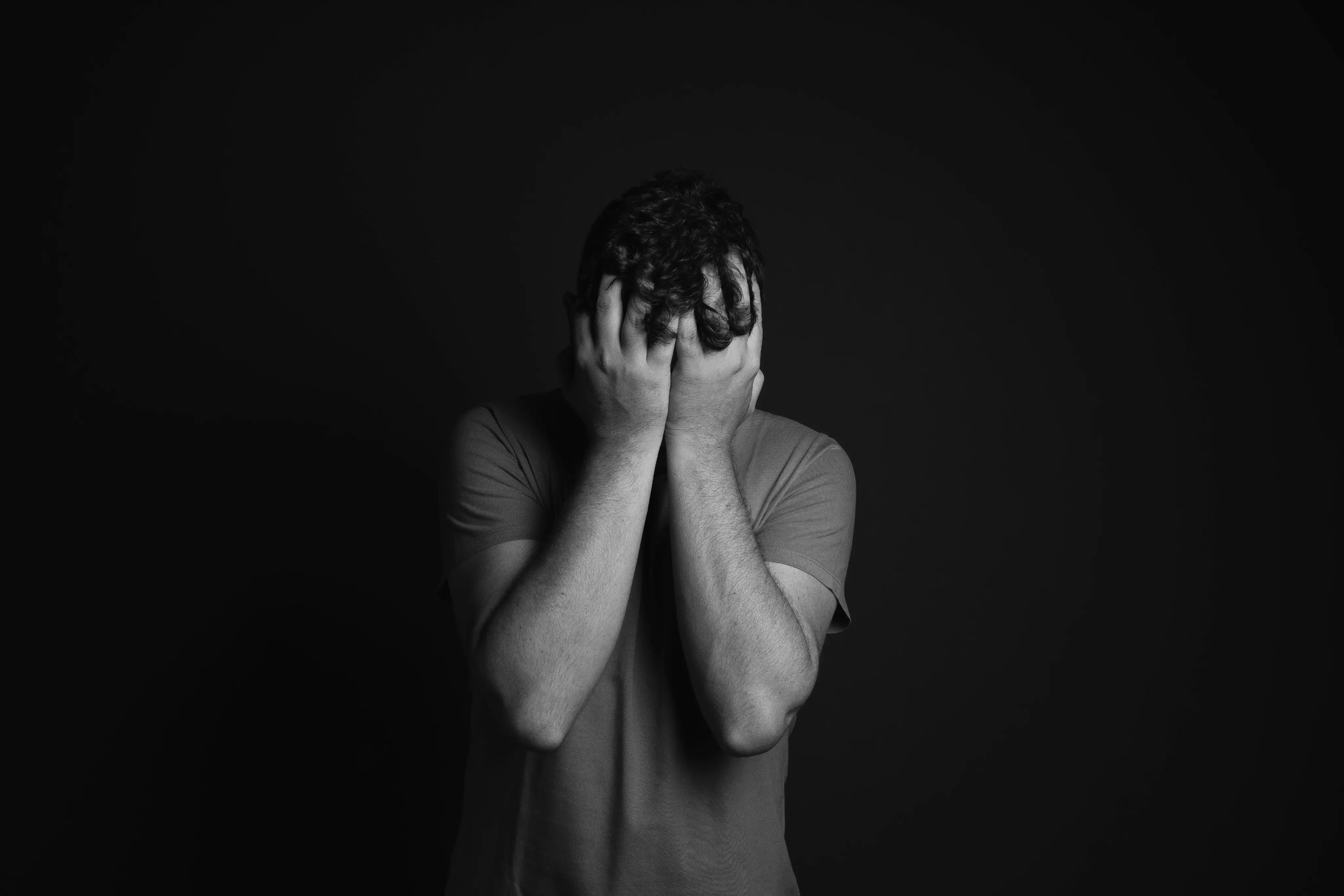Person holding their head in their hands